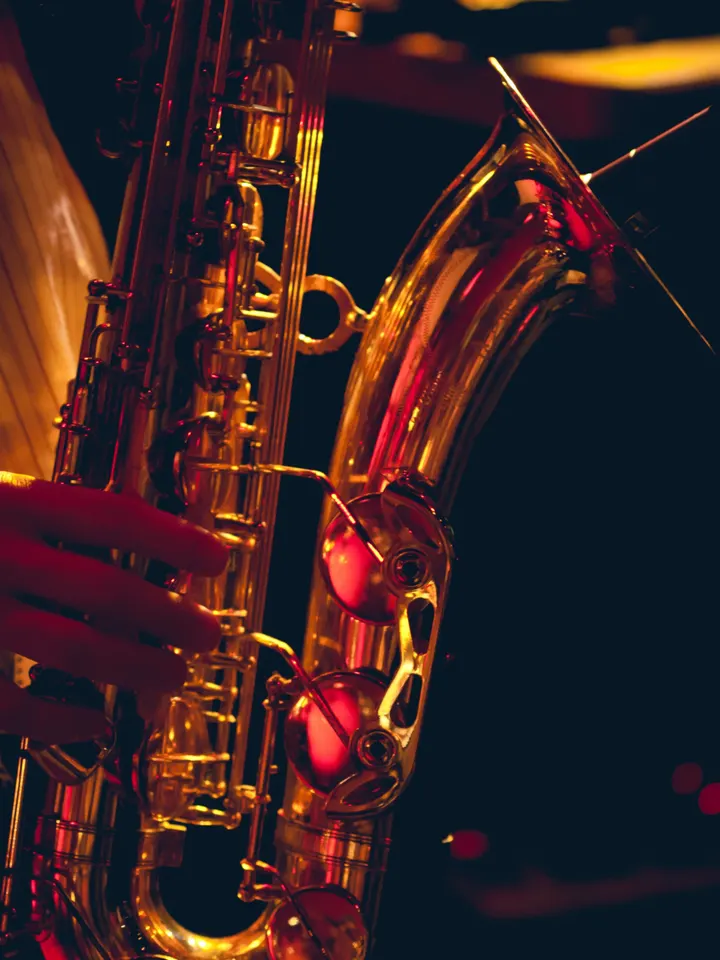 A saxophone being played under red stage light